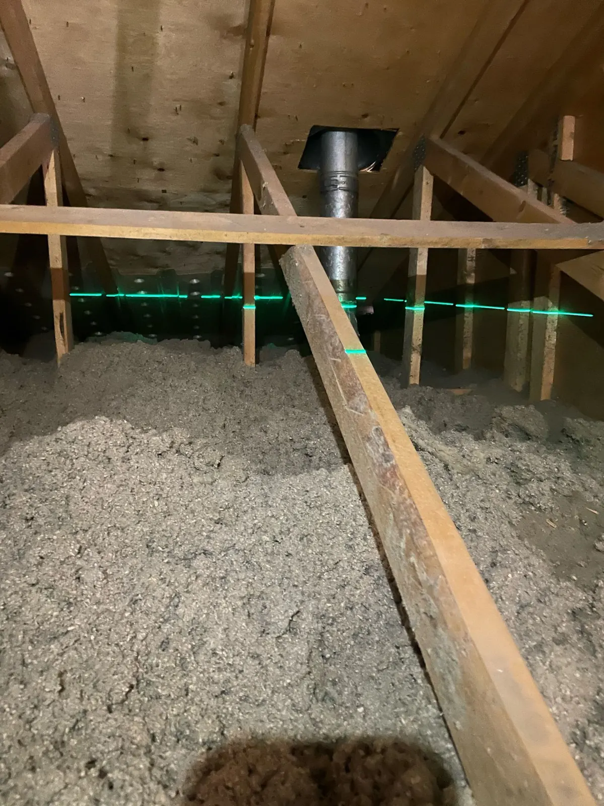 Attic floor with deep blown-in insulation between the trusses