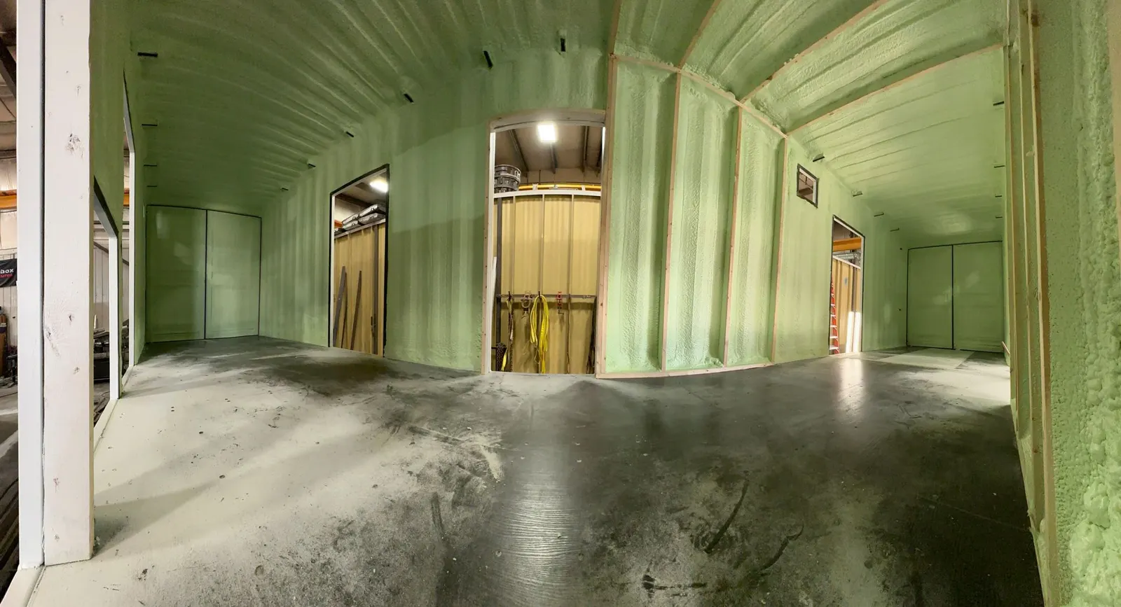 Large shop interior with green spray foam on walls and ceiling